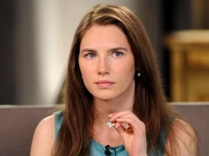 Amanda Knox is making hand gestures while talking.