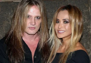 Sebastian Bach stands with his wife.