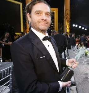 Zach Galifianakis holds the award in his hand.