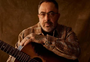 Aaron Lewis is holding a guitar.
