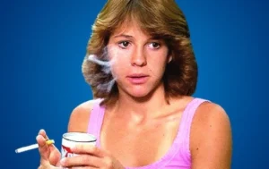 Christy McNichol holds a cigarette in her hand.