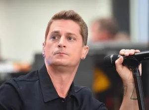 Rob Thomas is holding the mic.