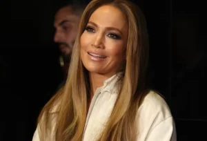 Jennifer Lopez is smiling and talking, and the boy's face is visible behind her.