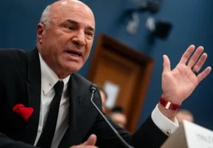 Kevin O'Leary is making a hand gesture while speaking into the mic.