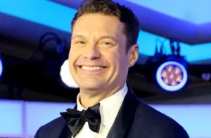 Ryan Seacrest is laughing.
