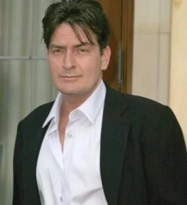 Charlie Sheen is smiling.