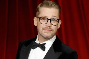 Macaulay Culkin is wearing glasses.