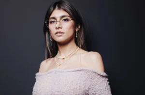 Mia Khalifa is smiling while wearing glasses.