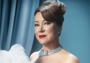 Jennifer Tilly is holding something in her hand.
