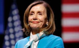 Nancy Pelosi stands smiling.