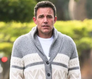Ben Affleck is standing outside wearing a jersey.