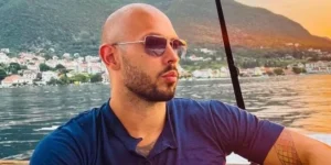 Andrew Tate is sitting by the sea.