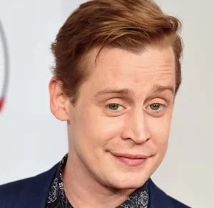 Macaulay Culkin is laughing.