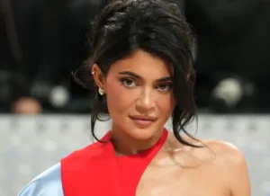 Kylie Jenner looks on smiling.