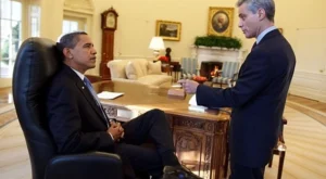 Barack Obama talking to a boy.