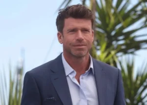 Taylor Sheridan is smiling.