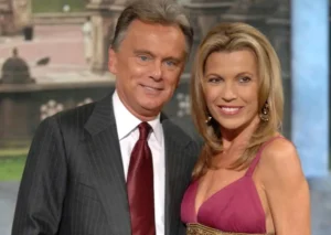 Pete Sajak is standing next to the girl and laughing.