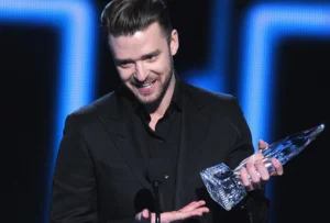 Justin Timberlake is bawling into the mic while holding the award.
