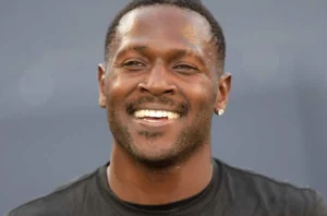 Antonio Brown is laughing, wearing a black shirt.