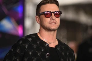 Justin Timberlake is standing with glasses on.