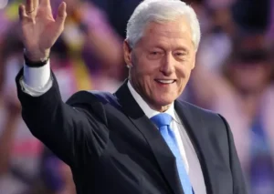Bill Clinton is laughing with his hands up.