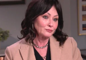 Shannen Doherty sits and smiles.