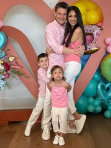 Rob Dyrdek is standing with his children, hugging his wife and laughing.