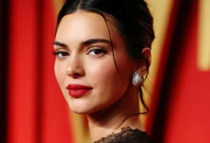 Kendall Jenner is smiling with makeup on.
