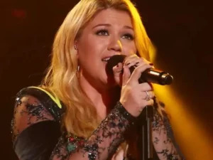 Kelly Clarkson is singing into the mic.