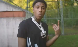 NBA Young Boy has his hand raised.