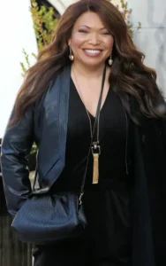 Teisha Campbell stands outside, laughing with her hands in her pockets.