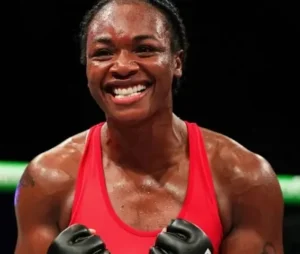 Clarissa Shields is laughing in a blue vest with gloves on her hands.