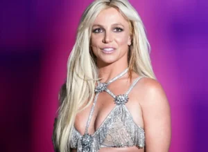 Britney Spears is laughing while wearing short clothes.