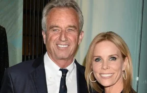 Robert F. Kennedy Jr. is standing next to a girl, laughing.
