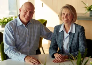 Steve Ballmer in 2025 is laughing while sitting with his wife.