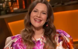 Drew Barrymore is laughing while wearing pink.