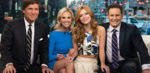 Two girls and a man are sitting and laughing with Tucker Carlson.