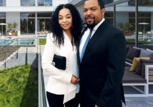 Ice Cube is standing outside with the girl.