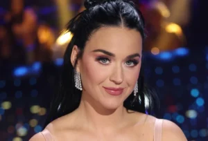 Katy Perry sits and smiles.