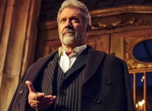 Mel Gibson is holding a chain in his hand.