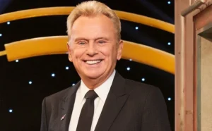 Pete Sajak is standing next to the girl and laughing....