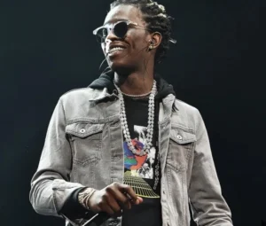 Young Thug is standing on stage and singing.