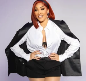 Natalie Nunn is wearing a white shirt and has her coat on.