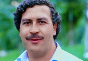 Pablo Escobar stands outside, smiling.