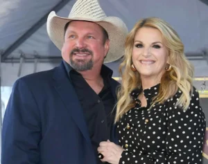 Garth Brooks and his wife stand together, laughing.