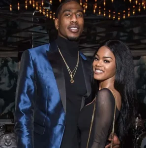 Iman Shumpert has her hand on the girl's waist and they are both laughing.