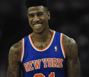 Iman Shumpert is laughing in uniform on the field.