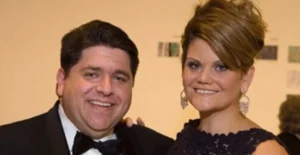 J.B. Pritzker and his wife stand together, smiling.