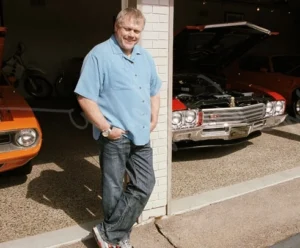 Craig Jackson is standing against a pillar, wearing a blue shirt.