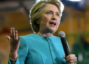 Hillary Clinton gestures with her hand while speaking into the microphone.